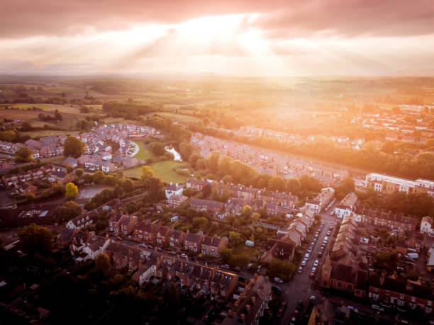 istock Sun bursting through clouds over traditional UK British houses 1354710744