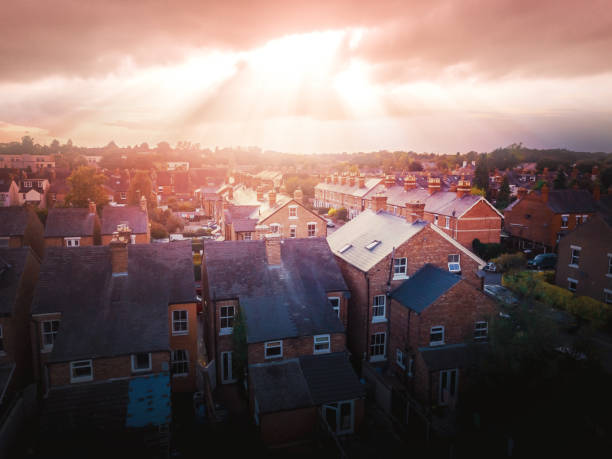 istock Sun bursting through clouds over traditional UK British houses 1354710818