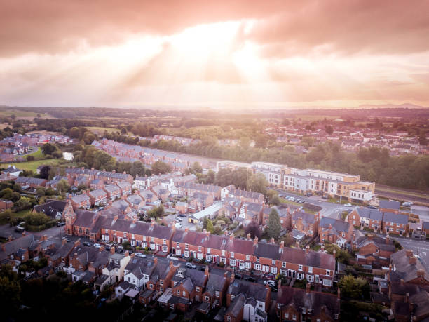istock Sun bursting through clouds over traditional UK British houses 1354710842