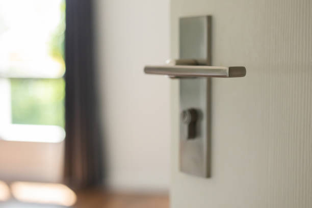 istock Modern door handle on white door with room interior 1354714574