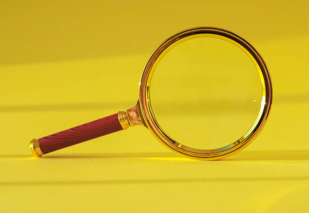 istock Magnifying glass on yellow background with light and shadow 1354717267