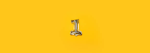 istock Foil balloon number One isolated on yellow background 1354718351