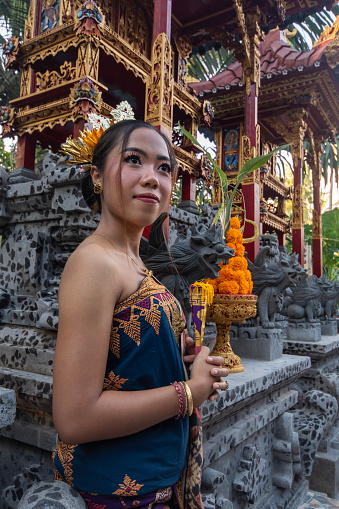 Portrait of girls with traditional costume with offering in bali temple.