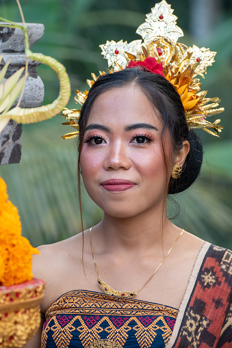 Portrait of girls with traditional costume with offering in bali temple.