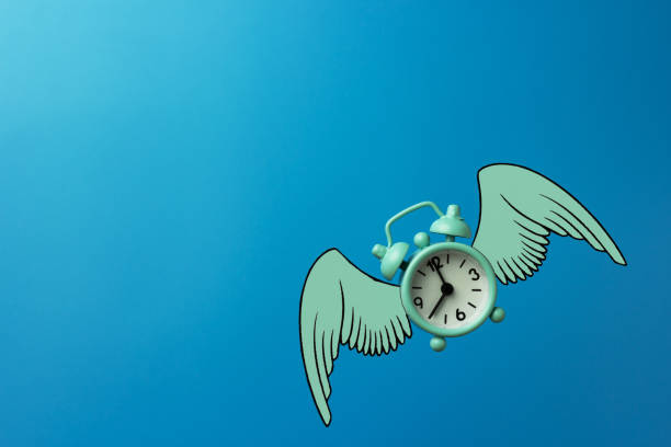 istock Flying blue alarm clock on blue background. 1354722884