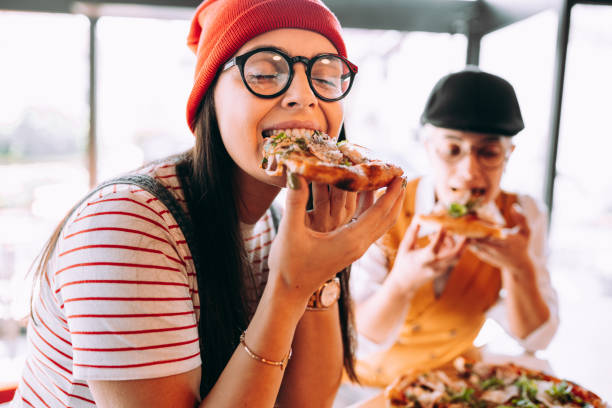 Girlfriends eat pizza Girlfriends eat pizza italian ethnicity stock pictures, royalty-free photos & images