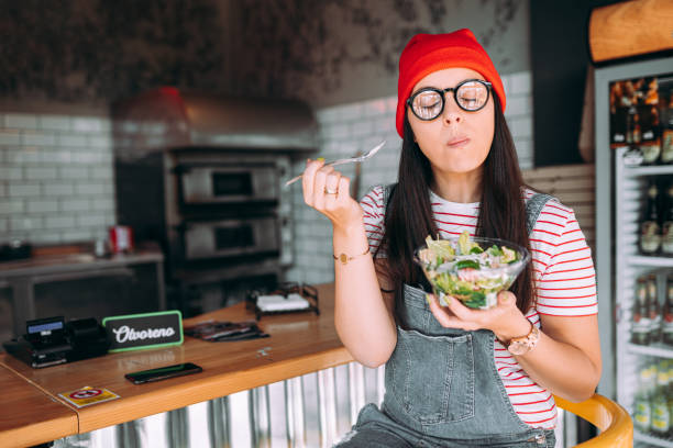 Young woman eating salad