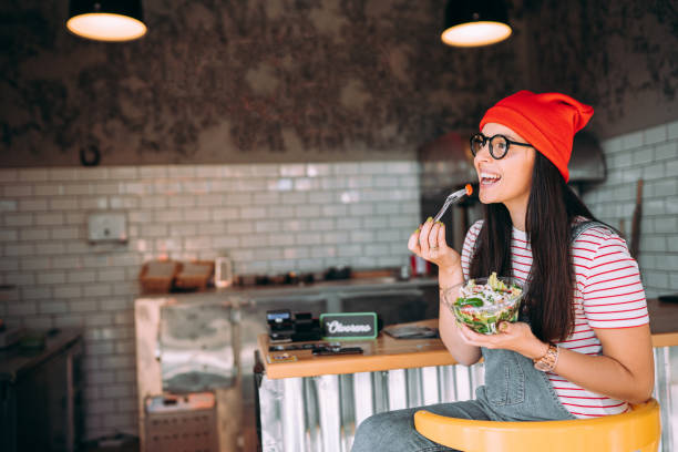 istock Young woman eating salad 1354723184