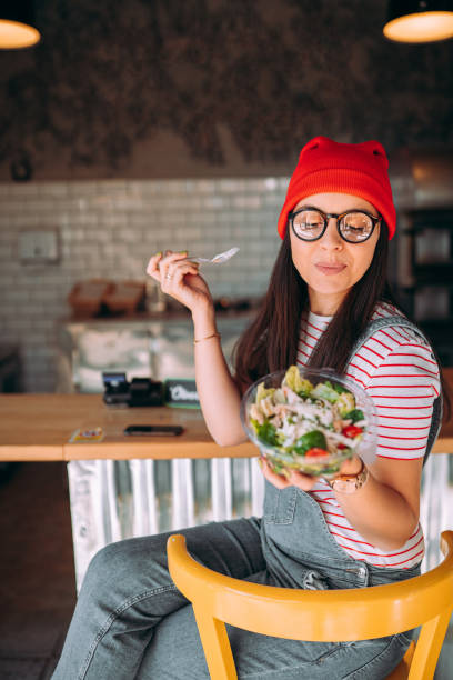 istock Young woman eating salad 1354723187