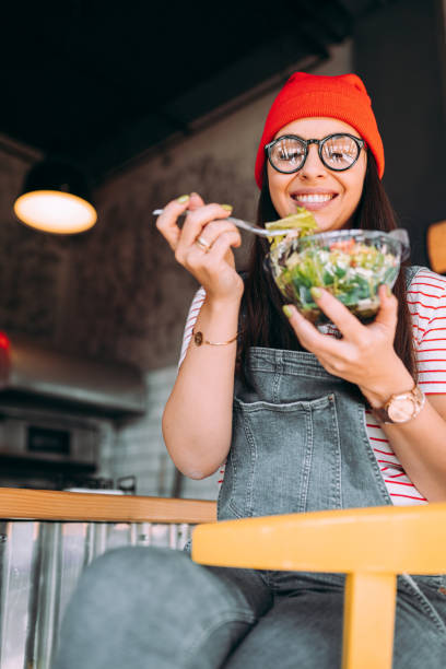 istock Young woman eating salad 1354723371