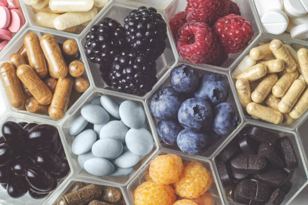 istock Fresh berries, pills and capsules in honeycomb like hexagonal jars 1354727519