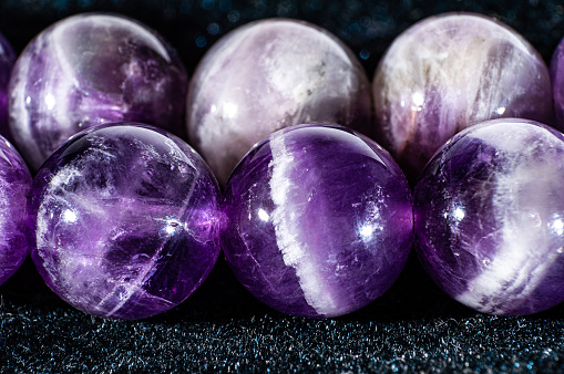 macro shot of amethyst round beads on a black background
