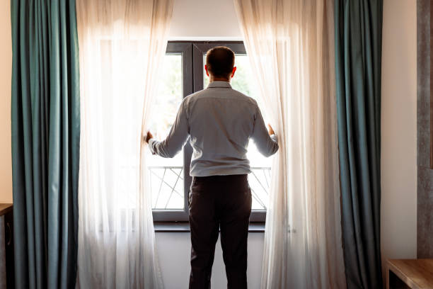 Mature businessman looking out of window Mature businessman looking out of window Staff Window Curtains stock pictures, royalty-free photos & images