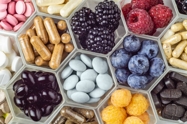 istock Fresh berries, pills and capsules in honeycomb like hexagonal jars 1354730025