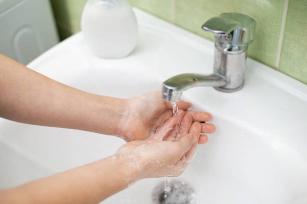 petite fille se lavant soigneusement les mains - cream coloured sink faucet home interior photos et images de collection