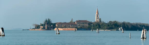 blick vom lido auf die verlassene insel poveglia, eine ehemalige psychiatrische klinik von venedig - lido stock-fotos und bilder