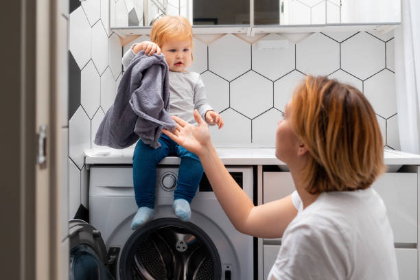istock A mother and her little daughter loading laundry in the washing machine together 1354735263