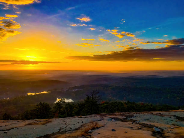istock Warm glow from sunrise over fog covered forst on a partly cloud day 1354737974