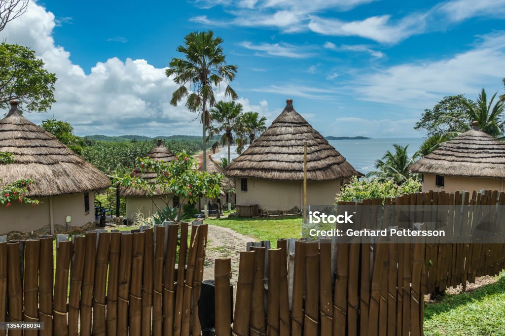 African bungalow with thatched roof African bungalow with thatched roof and built in old tradition on a hill in Axim overlooking the sea located in Ghana West Africa Ghana Stock Photo