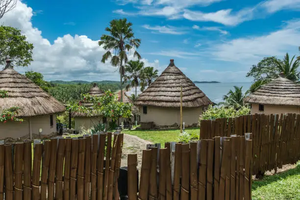 African bungalow with thatched roof and built in old tradition on a hill in Axim overlooking the sea located in Ghana West Africa