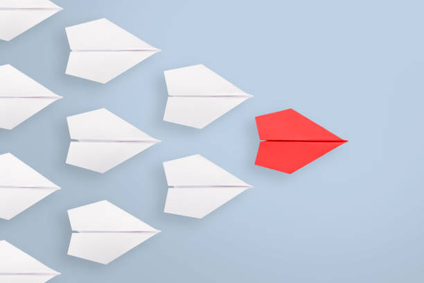 istock Leadership concepts with red paper airplane leading among white 1354738568