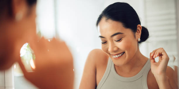 istock Morning Routine: Happy Asian Woman Looking Herself in the Mirror 1354745033