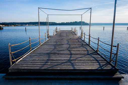 Wooden pier with metal frames and a fence on the sea