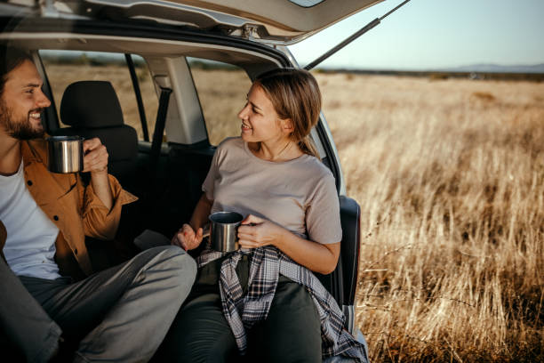 istock Loving couple drinking coffee in car trunk 1354751578