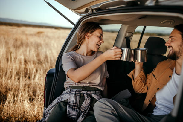 istock Loving couple drinking coffee in car trunk 1354751672