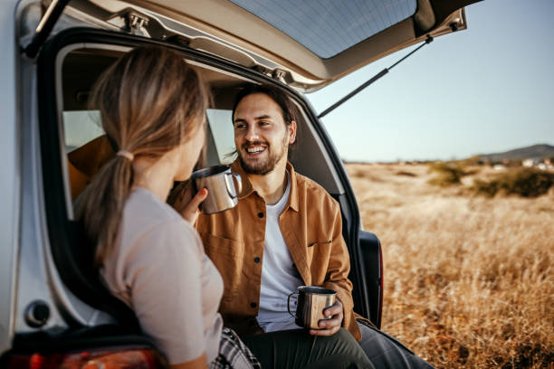 istock Loving couple drinking coffee in car trunk 1354751830