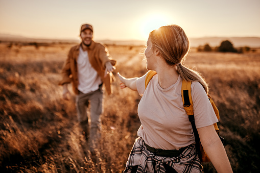 Couple about to hold hands while walking on agricultural field