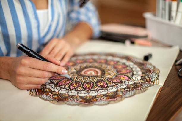 istock Young beautiful girl with long hair draws a circular mandala pattern 1354754140