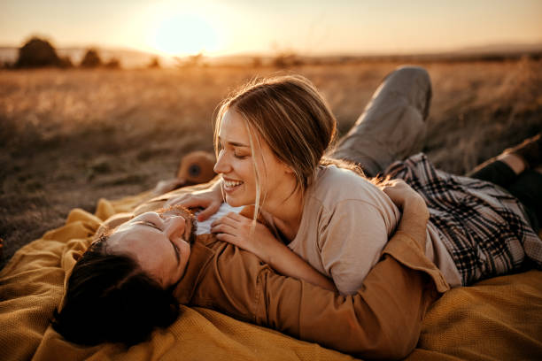 istock Loving couple relaxing on field 1354754184