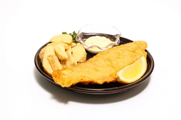 istock Fish and chips on the black dish isolated on a wite background. 1354754420