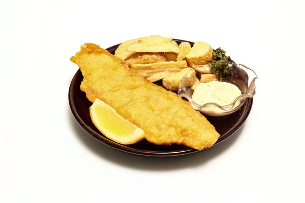 istock Fish and chips on the black dish isolated on a wite background. 1354754455