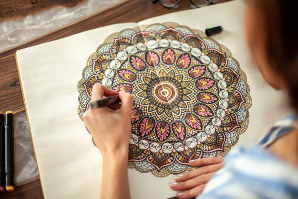 istock Young beautiful girl with long hair draws a circular mandala pattern 1354755305