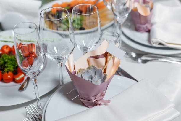 istock Gift for guests at the wedding - blank invite guest card and cute succulent. Party table setting with napkin, wineglasses, dish. Reception decor in restorant 1354756767