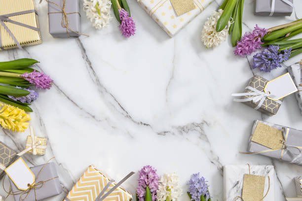 istock Top view trendy composition with festive wrapped gift boxes ribbon bow decorated by bloom flowers 1354757369