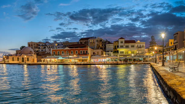 the blue hour in Chania harbour with reflections in the sea from the sky and restaurants, Crete stock photo