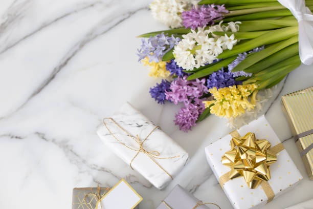 istock Top view trendy composition with festive wrapped gift boxes ribbon bow decorated by bloom flowers 1354759268