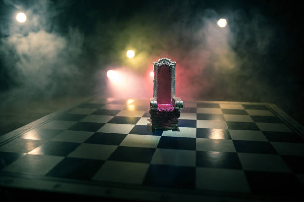 istock Red royal chair miniature on wooden table. Medieval Throne on chessboard. Chess board game concept of business ideas and competition and strategy ideas concept. 1354760310