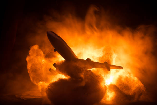 istock Air Crash. Burning falling plane. The plane crashed to the ground. Decorated with toy at dark fire background. Air accident concept. 1354760352