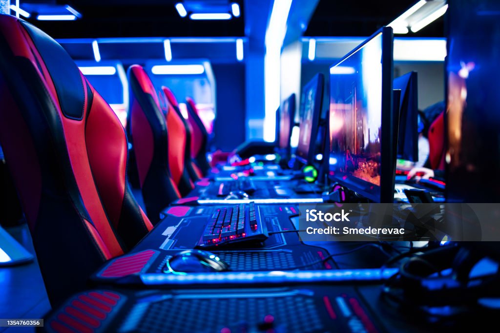 Game room interior with modern ambient lights and powerful super computers, consoles, keyboards for playing video games. Entertaining industry. eSports Stock Photo
