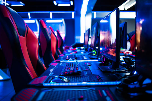 Game room interior with modern ambient lights and powerful super computers, consoles, keyboards for playing video games. Entertaining industry. stock photo