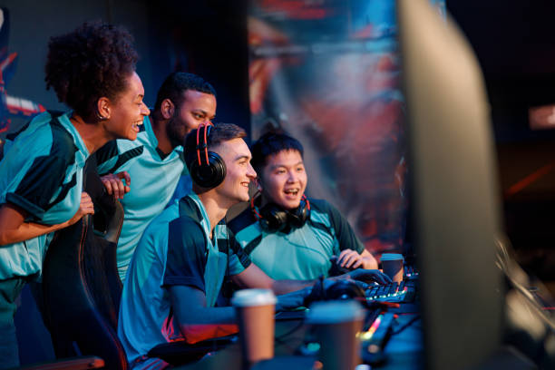 happy gamers involved in online video game at computer club - esport audience bildbanksfoton och bilder
