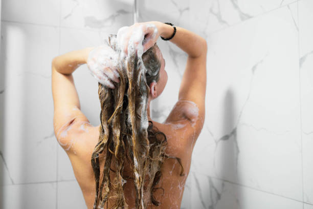 A beautiful woman takes a shower and takes care of her body and hair A beautiful woman takes a shower and takes care of her body and hair washing hair stock pictures, royalty-free photos & images