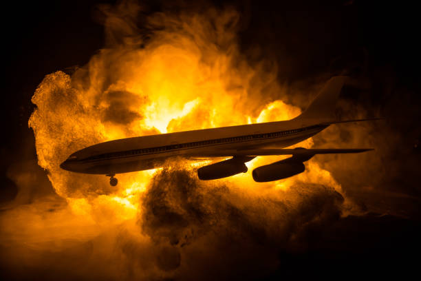 istock Air Crash. Burning falling plane. The plane crashed to the ground. Decorated with toy at dark fire background. Air accident concept. 1354764479