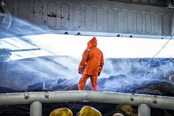 Photo of Fisherman on a trawler, over a fishing net
