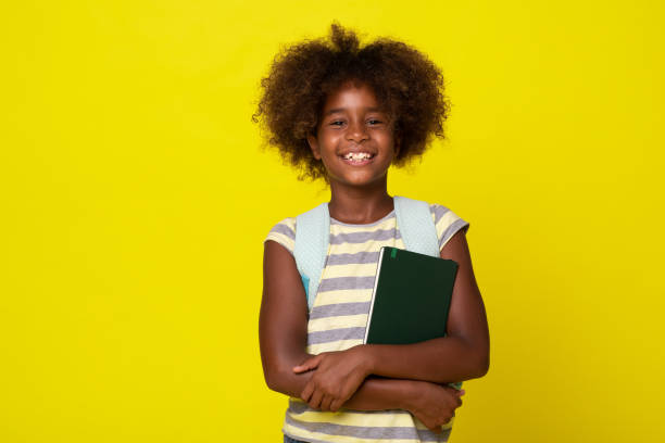 istock Portrait of a school girl with notebook and backpack 1354765930