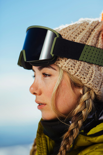 Portrait of a happy woman skiing smiling outdoors and looking at the camera wearing goggles â winter sports concepts
